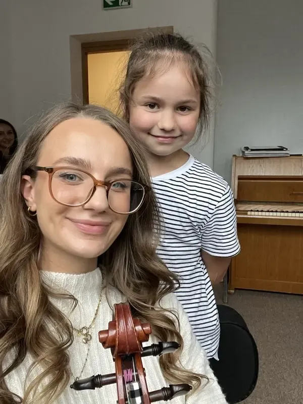 Gabriela Higson-Spence with a young student holding her violin after a lesson in Kraków